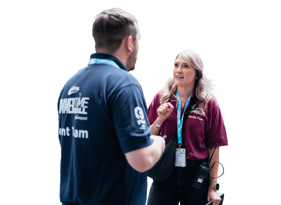 Two people wearing event badges are engaged in conversation.