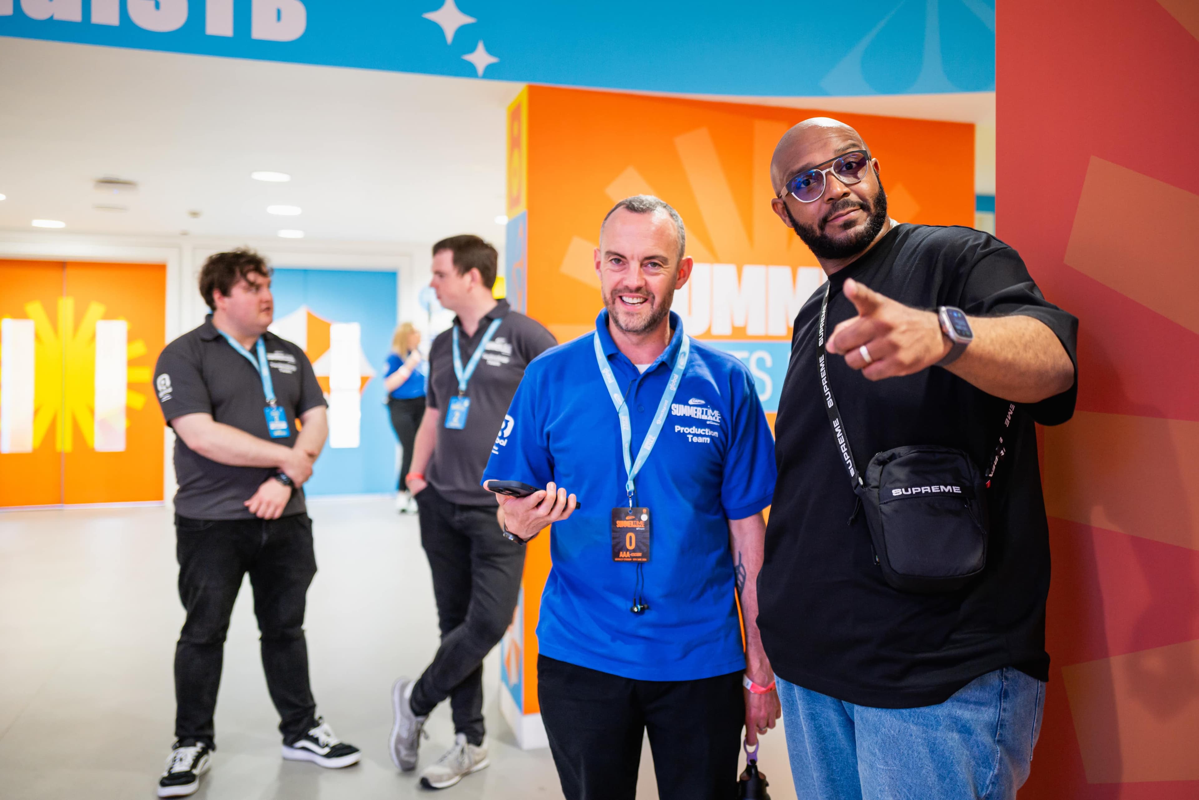 Two men at Global's summertime ball stand side by side against a branded wall backdrop.