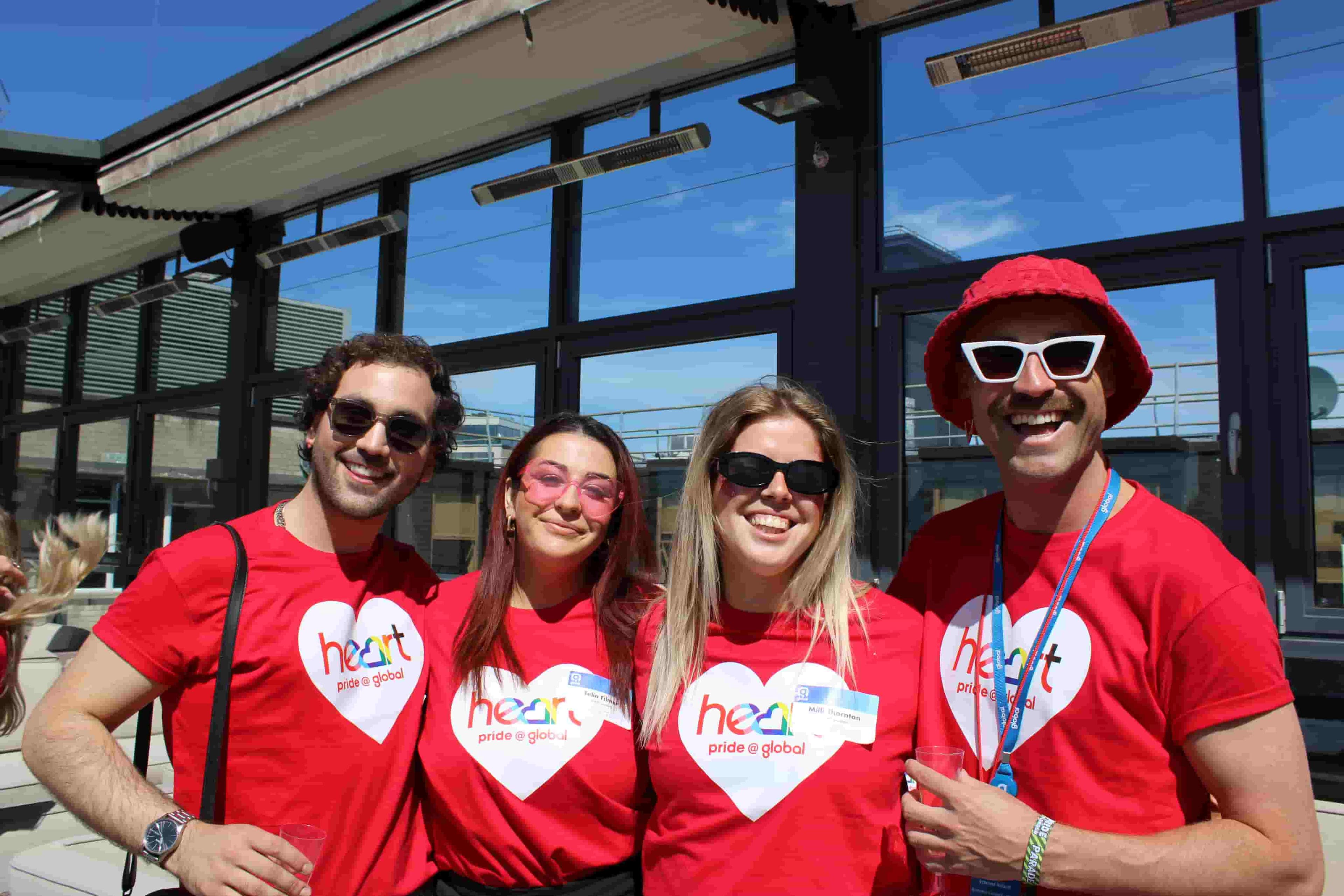 A joyful group of colleagues striking a pose for a memorable photo at a Global Pride event.