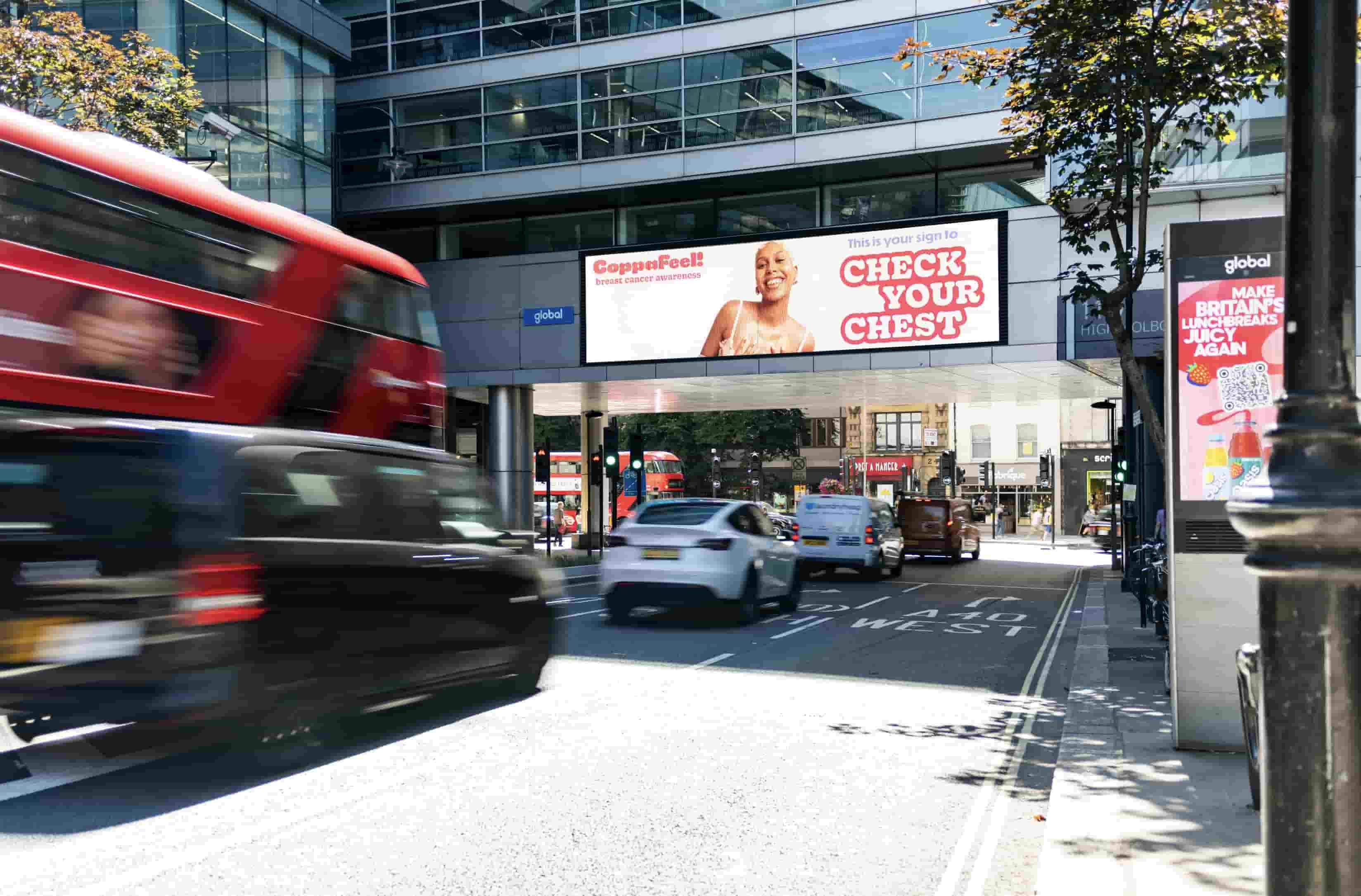 Cars driving underneath an office building showing billboards and other out of home advertisement